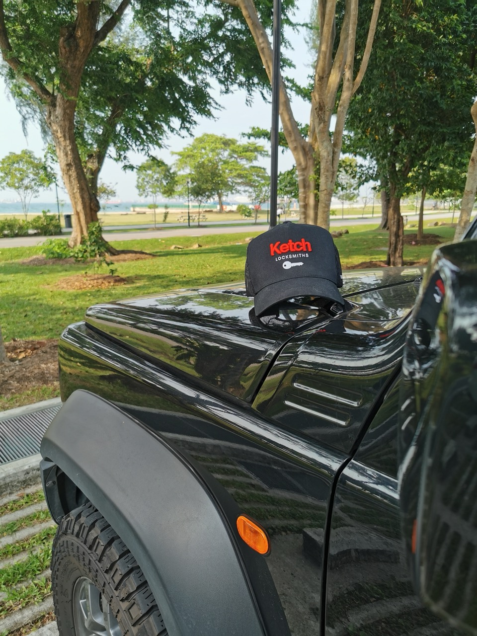 Ketch cap resting on the bonnet of the company truck at East Coast Park, Singapore.