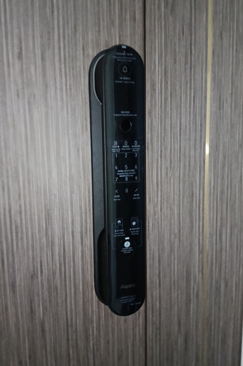 Aqara D100 smart lock installed on a wood-veneer door.