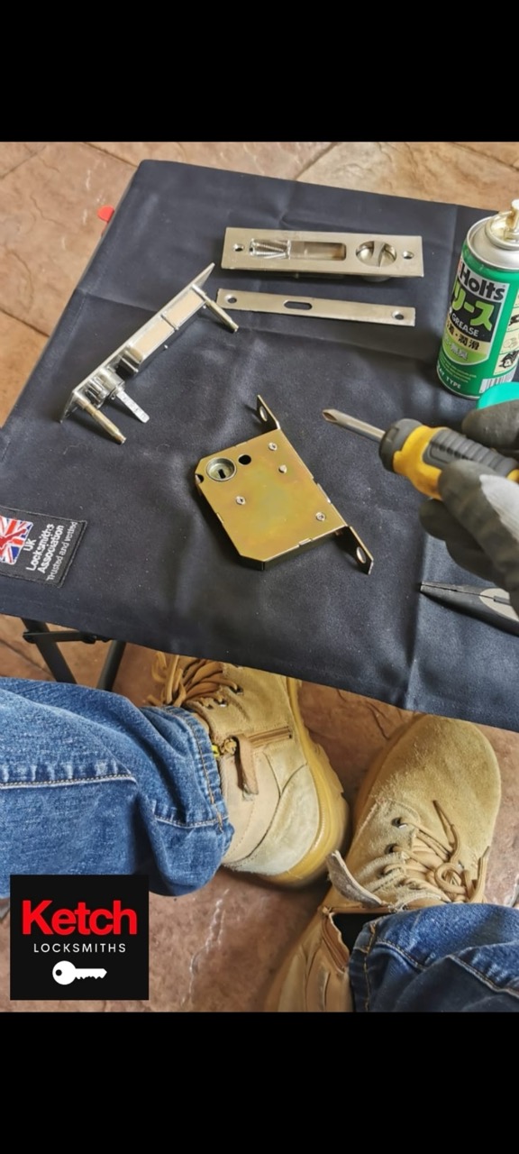 Locksmith tool roll laid out in the field with mortice parts and grease.