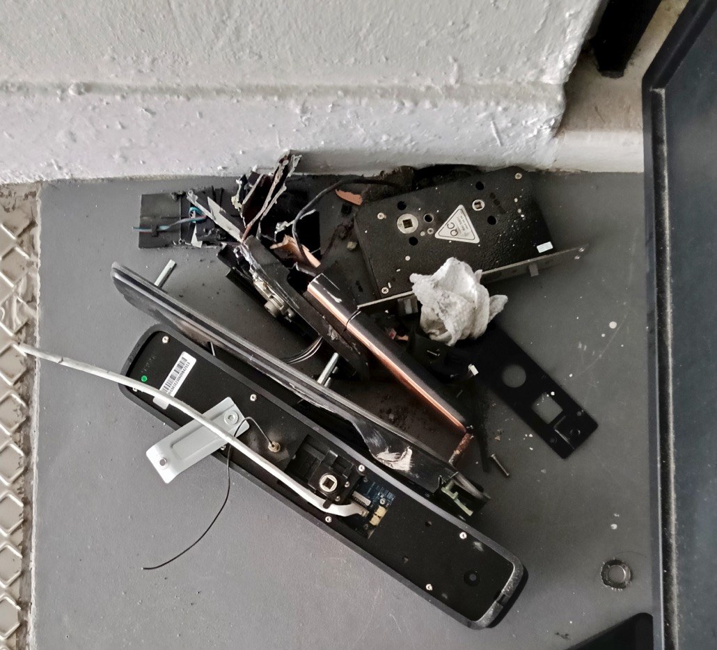 Faulty digital lock removed and disassembled on the floor.